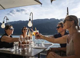 amis à l'apéritif sous parasol vue sur le lac d'annecy